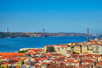 Views of Lisboa where you can see the roofs of their houses, Tajo River, April 25 bridge and Cristo...