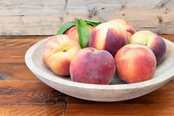 Melocotones rojos en un plato de madera