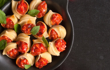 Stuffed large shells pasta with meat and tomatoes in sauce. Conchiglioni. Italian cuisine. Copy space. the view from the top