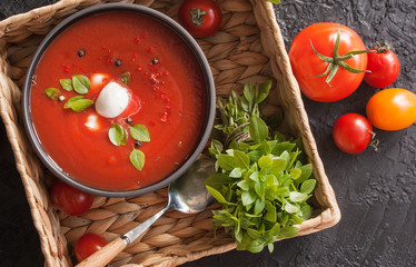 Summer cold tomato vegetable soup Gazpacho on a wicker tray. Vegetarian cuisine. The view from the...
