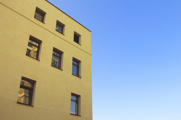 Yellow modern architecture building top corner on blue sky background