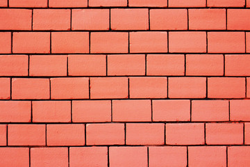 Pink colored brick wall background with black gaps