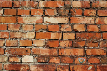 Red uneven messy brick wall with little heart in the corner
