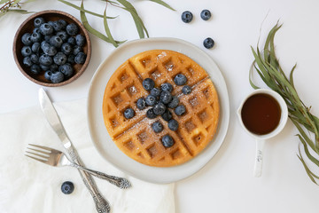 Belgian Waffle with Blueberries and Maple Syrup, Dusted with Powdered Sugar, Flay Lay on White Background, Copy Space