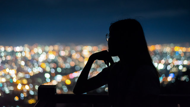 silhouette Woman portrait  in city night light bokeh background , Chiang mai ,Thailand
