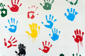 hand prints in many colors on a white wall