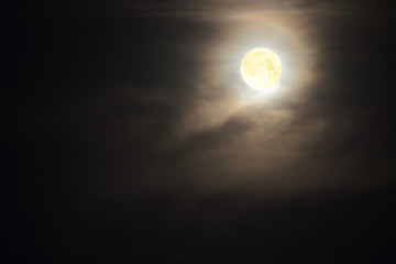 Obraz premium Full moon in clouds on black sky background