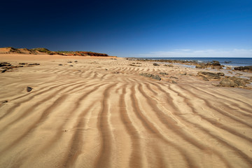 Western Australia - coast line at Dampier Peninsula with rippled sand dune and hill in the background in morning light