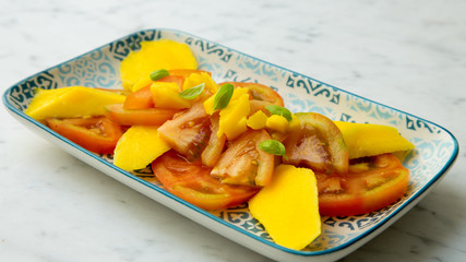 Tomato salad with mango. Summer meal.