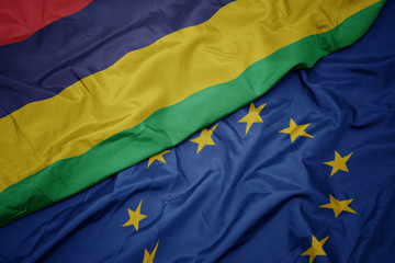 waving colorful flag of european union and flag of mauritius.