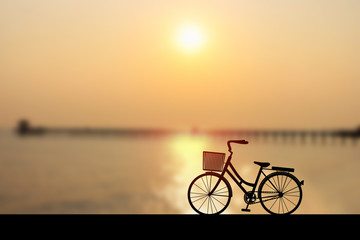 Silhouette women's style bike at sunset on seascape with bridge and cloud sky. Vector illustration design