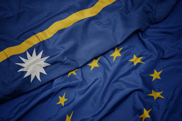waving colorful flag of european union and flag of Nauru .