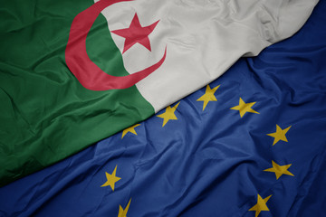 waving colorful flag of european union and flag of algeria.