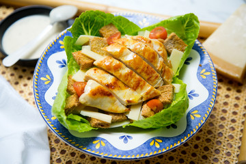 Chicken dish from a restaurant. Cesar Salad.