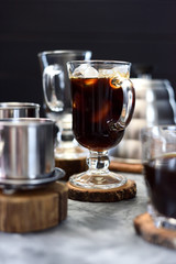 Making Vietnamese black drip ice coffee in irish mug on black background