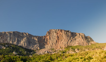 Russian mountains. Crimea. Summer mountains background. Forest and mountains in the sun on the background of a cloudy sky above the peninsula of Crimea. Sunny, bright, saturated raster photo