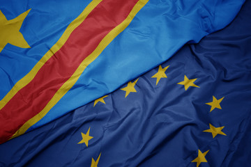 waving colorful flag of european union and flag of democratic republic of the congo.