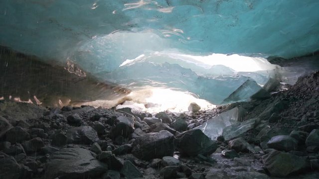 Slow Motion/Pan Up: Water Dripping From Sunny Holes In Thick Glacier - Mendenhall Glacier, Alaska