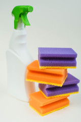 cleaning agent and multi-colored sponges on a white background. Housework concept.