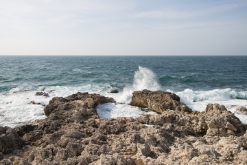 Sea waves crashing against the rocks. Day