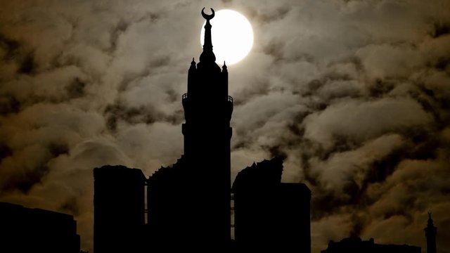 Mecca Clock Tower, Time Lapse by Night with Full Moon, Dark Sky and Abraj Al Bait Skyscrapers, Makkah, Saudi Arabia