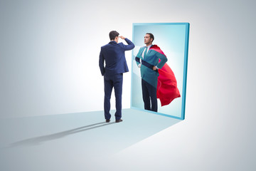 Fototapeta premium Businessman seeing himself in mirror as superhero