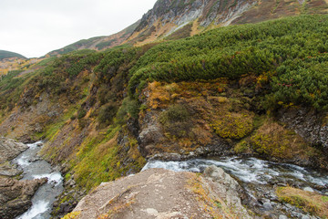 Beautiful waterfall in mountains, scenic autumn landscape in Kamchatka