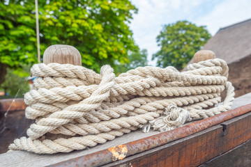 Wooden bollards on an old boat and a rope.
