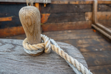 Wooden bollards on an old boat and a rope.