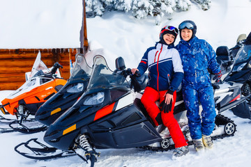 Smiling young woman riding a snowmobile