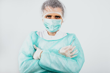 Man dressed in a green surgical apron and a mask on his face on a white background. Medical and pharmaceutical concept. Doctor or surgeon. Preparation for surgery, treatment of people.
