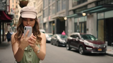 Parisian walks around Manhattan and takes photos on a phone, first time in New York, traveler's life in big city, everyday moment.