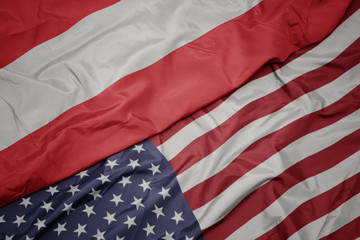 waving colorful flag of united states of america and national flag of austria.