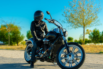 Fototapeta na wymiar Biker dressed in black in his black bike.