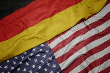 Obraz premium waving colorful flag of united states of america and national flag of germany. macro