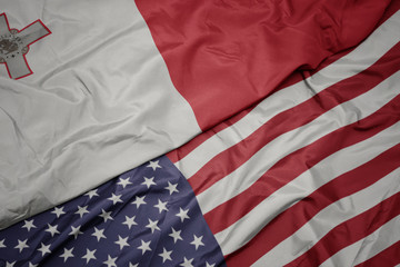 waving colorful flag of united states of america and national flag of malta. macro