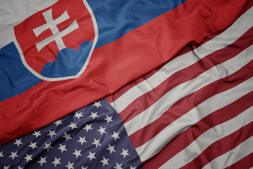 waving colorful flag of united states of america and national flag of slovakia. macro