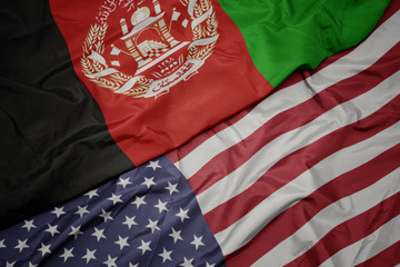 waving colorful flag of united states of america and national flag of afghanistan.