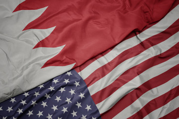 waving colorful flag of united states of america and national flag of bahrain.