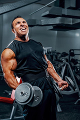Fototapeta na wymiar Muscular Men Lifting Weights at the Gym