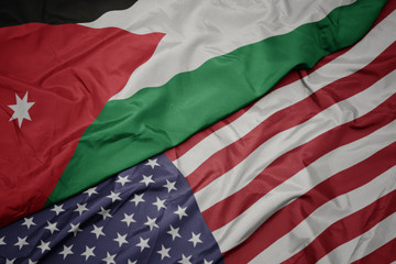 waving colorful flag of united states of america and national flag of jordan.