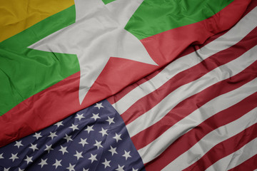 waving colorful flag of united states of america and national flag of myanmar.