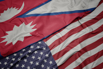 waving colorful flag of united states of america and national flag of nepal.