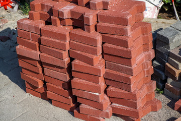 Stack of colored Interlocking pavers made from cement or concrete on a construction site