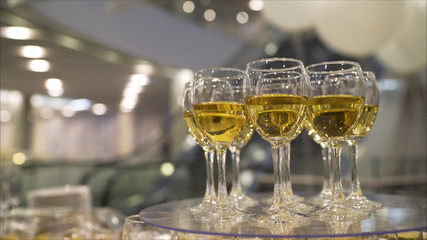 Cinemagraph - Pouring a Glass of White Wine agains the Sunset Sky. 120 fps, 4K DCi. Relaxing Cozy Evening on Terrace. Unrecogizable female hand holding a wineglass on patio. Motion photo. Lens Flare.