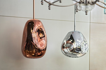 Different modern streamlined mirror copper chandeliers. Metal copper shaped pendant lamps. Loft style