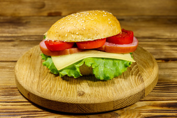 Fresh delicious homemade cheeseburger on wooden table