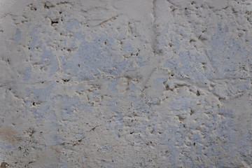 old dirty concrete wall worn out by time and weather painted white