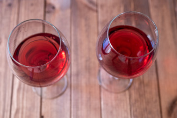 two glasses of red wine on a wooden table