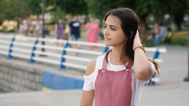 Dainty brunette girl standing and waiting for her he-man at Dnipro in slo-mo  